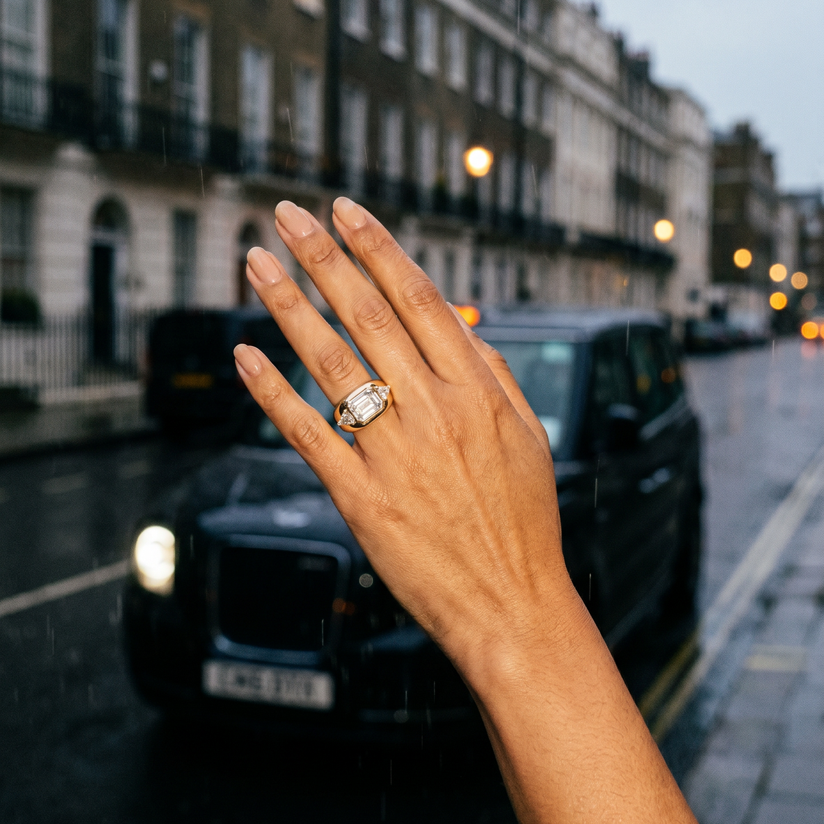 Hand with a ring on a city street with a black taxi in the background
