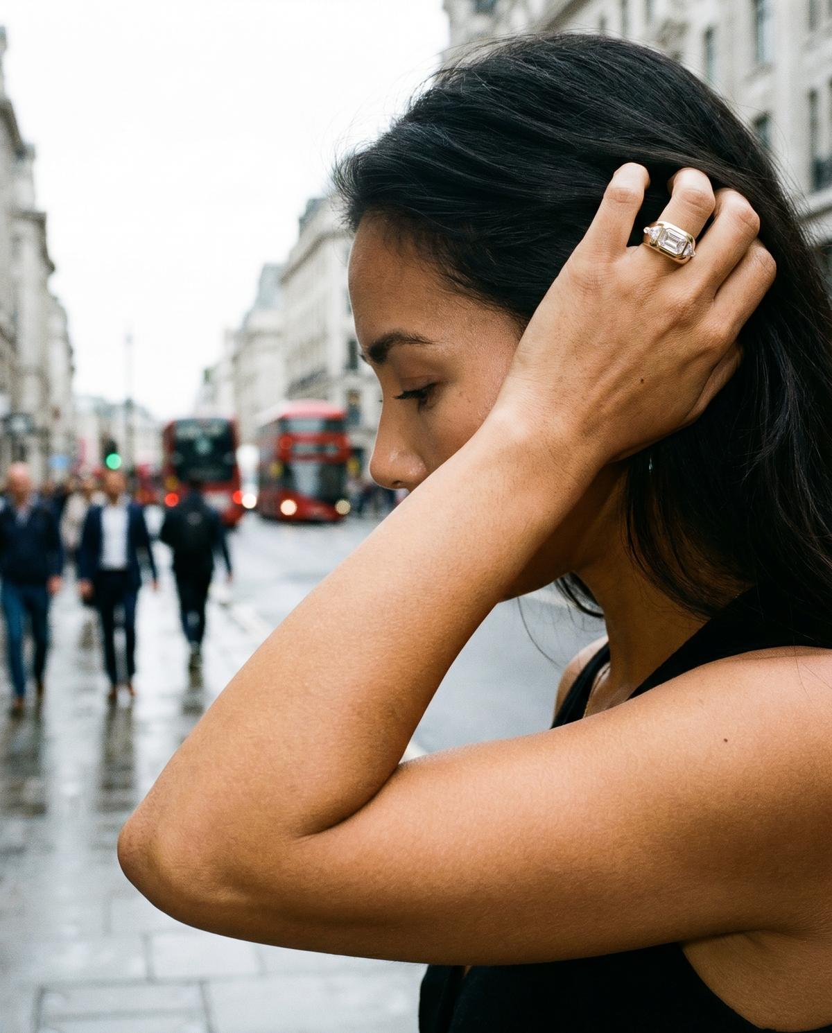 Woman adjusting her hair on a city street with blurred background